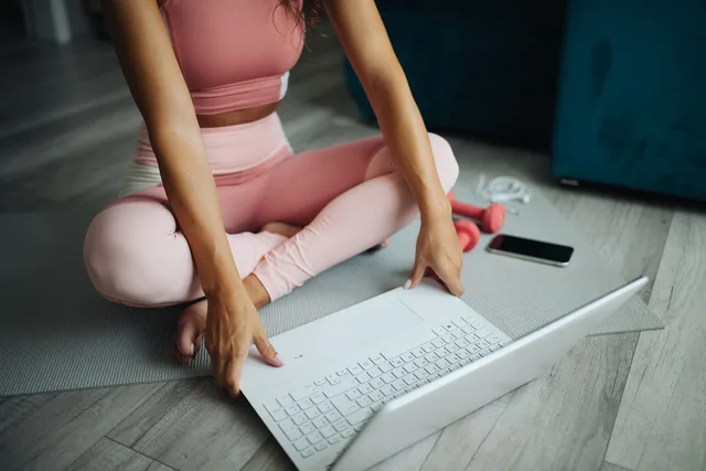 Fitness girl using laptop for online yoga lesson. How fitness creators check an HCPC registration and Active Lives data